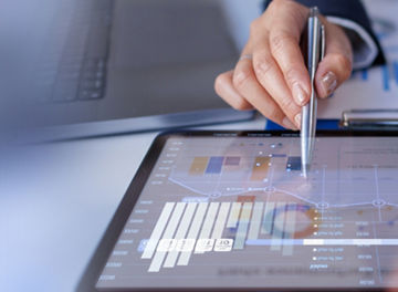 Person using a tablet displaying charts and analytics data.