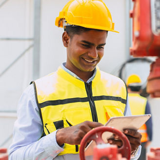 happy indian engineer safety staff worker work control operate valve gas pipe oil industry