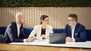 people sitting by a table with a computer