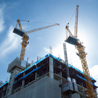 Silhouette Construction site background. Hoisting cranes and new multi-storey buildings. Industrial background. Building construction site work against blue sky.