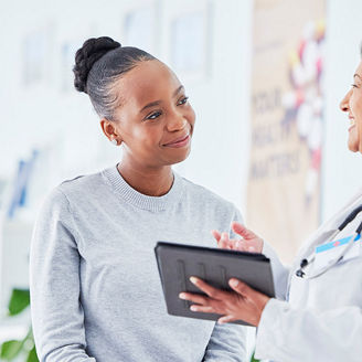 doctor holding a tablet taking to patient