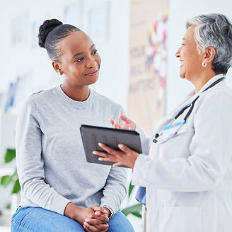 Doctor holding a tablet taking to patient