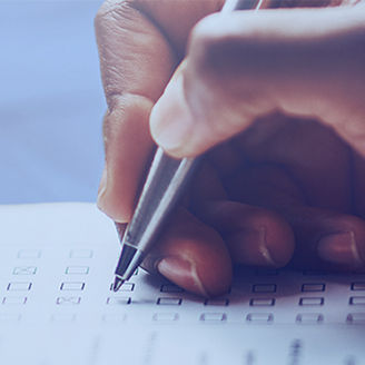 Hand schreibt mit Stift auf einen Fragebogen