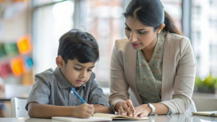 An Indian teacher giving one-on-one attention to a student, helping with specific educational needs and challenges.