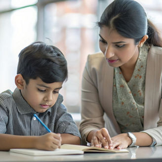 An Indian teacher giving one-on-one attention to a student, helping with specific educational needs and challenges.