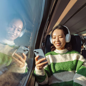 eine Dame guckt auf das Handy im Zug