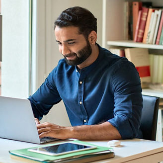 Busy indian ethnic business man professional manager entrepreneur remote learning online typing on laptop sitting in office at home using computer software working on digital market data technology.