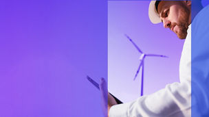 man kijkt naar tablet voor een windmolen