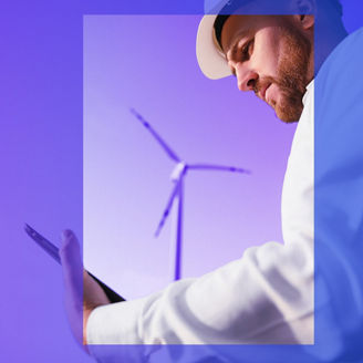 man kijkt naar tablet voor een windmolen