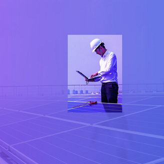 Man kijkt op zijn laptop terwijl hij tussen zonnepanelen staat