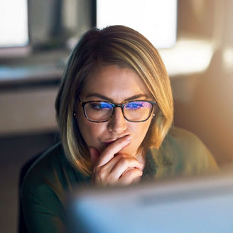 Shot of a young businesswoman working late on a computer in an office