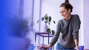 woman standing at a desk with a laptop
