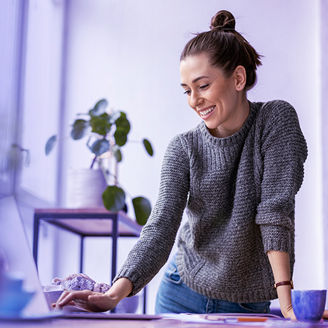 woman standing at a desk with a laptop