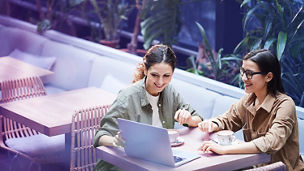 two colleagues working together behind laptop