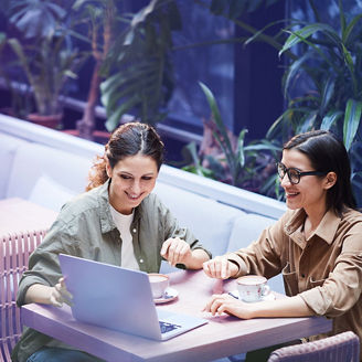 two colleagues working together behind laptop