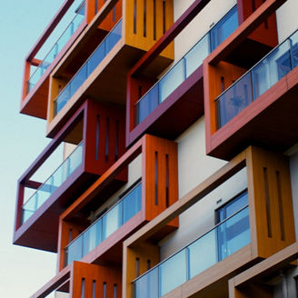 Hauswand mit Balkonen vor blauem Himmel