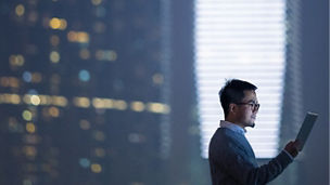 Smart businessman using digital tablet in city