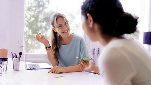 Two friends working at home together- taking notes