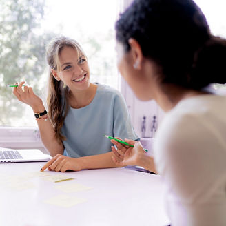Two friends working at home together- taking notes