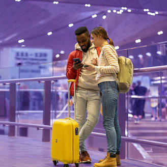 two people at the airport with a suitcase