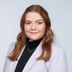 Porträt von Eva-Maria Buger vor einem hellgrauen Hintergrund