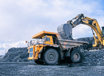 Mining excavator loading rocks in mining truck