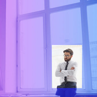 Serious businessman standing by the window in office