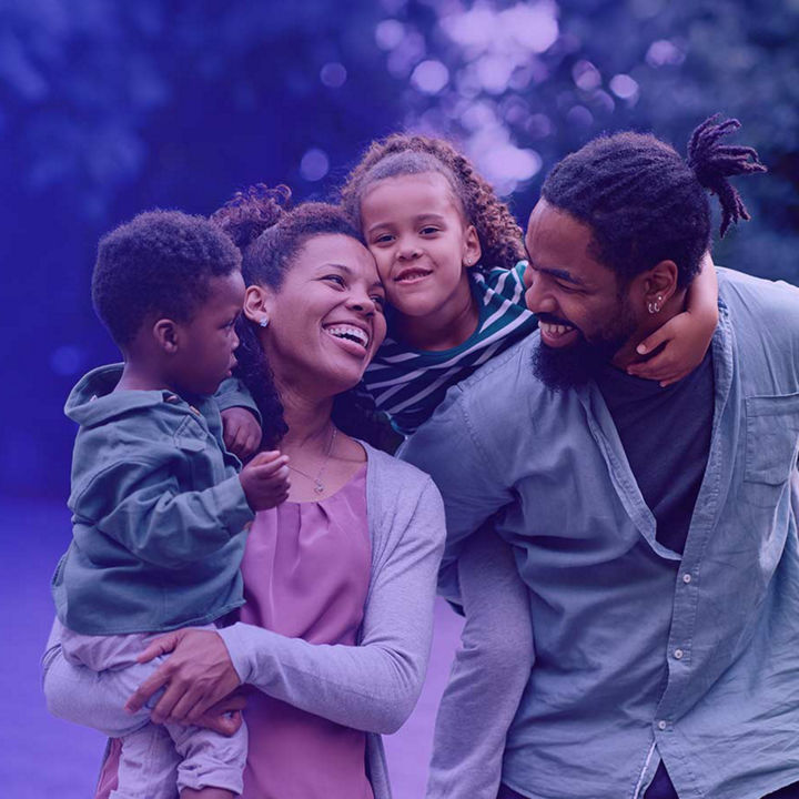 Family of four with parents carrying small children