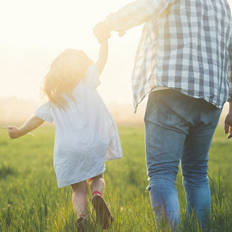 father and child walking on sunset
