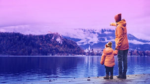 Father and son standing near a lake