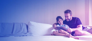 Father and daugter are watching something on an iPad ina a residential apartment