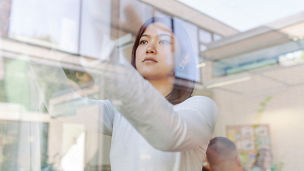 female student sticking post-its on window