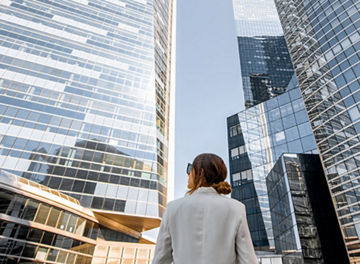 woman in city with tall buildings