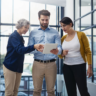 Shot of a group of colleagues looking at a tablet in the office.