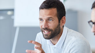 A portrait of a young smiling businessman  a meeting and presentation in the office. Business concept
