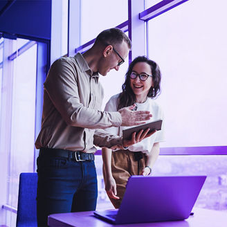 Man and woman discussing over laptop