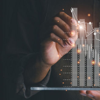 Businessmen are using tablet computers to analyze trends of fast-growing businesses with rising graph bars on a black background.