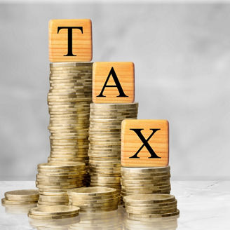 Wooden cubes with the word Tax on money pile of coins