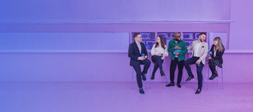 Five work collegues sitting at a bar banner light purple