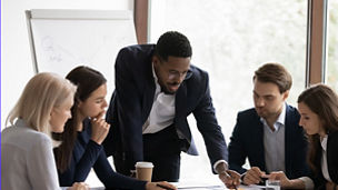 Five people discussing buisness at table