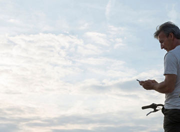 Man controleert telefoon op fiets