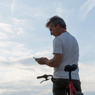 Man looking at his smartphone on a bike