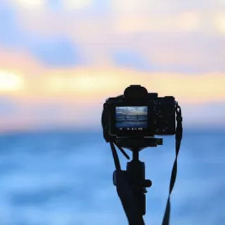 Kamera mit Aufnahme vom Meer bei Sonnenuntergang