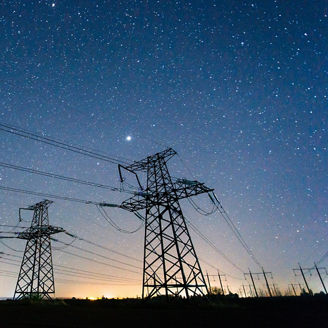 Four electric poles with night sky in background