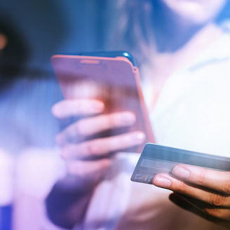 Frau hält Handy und Kreditkarte