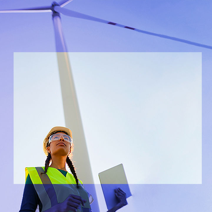 Woman with helmt in front of wind turbine