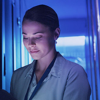 Frau in Serverraum am Tablet