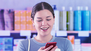 Frau scannt produkt mit Handy