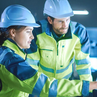 A woman and a man wearing hard hats