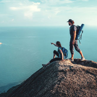 Man and woman stand on on top of cliff at tropical island , enjoying view of nature; Shutterstock ID 1718161858; purchase_order: -; job: -; client: -